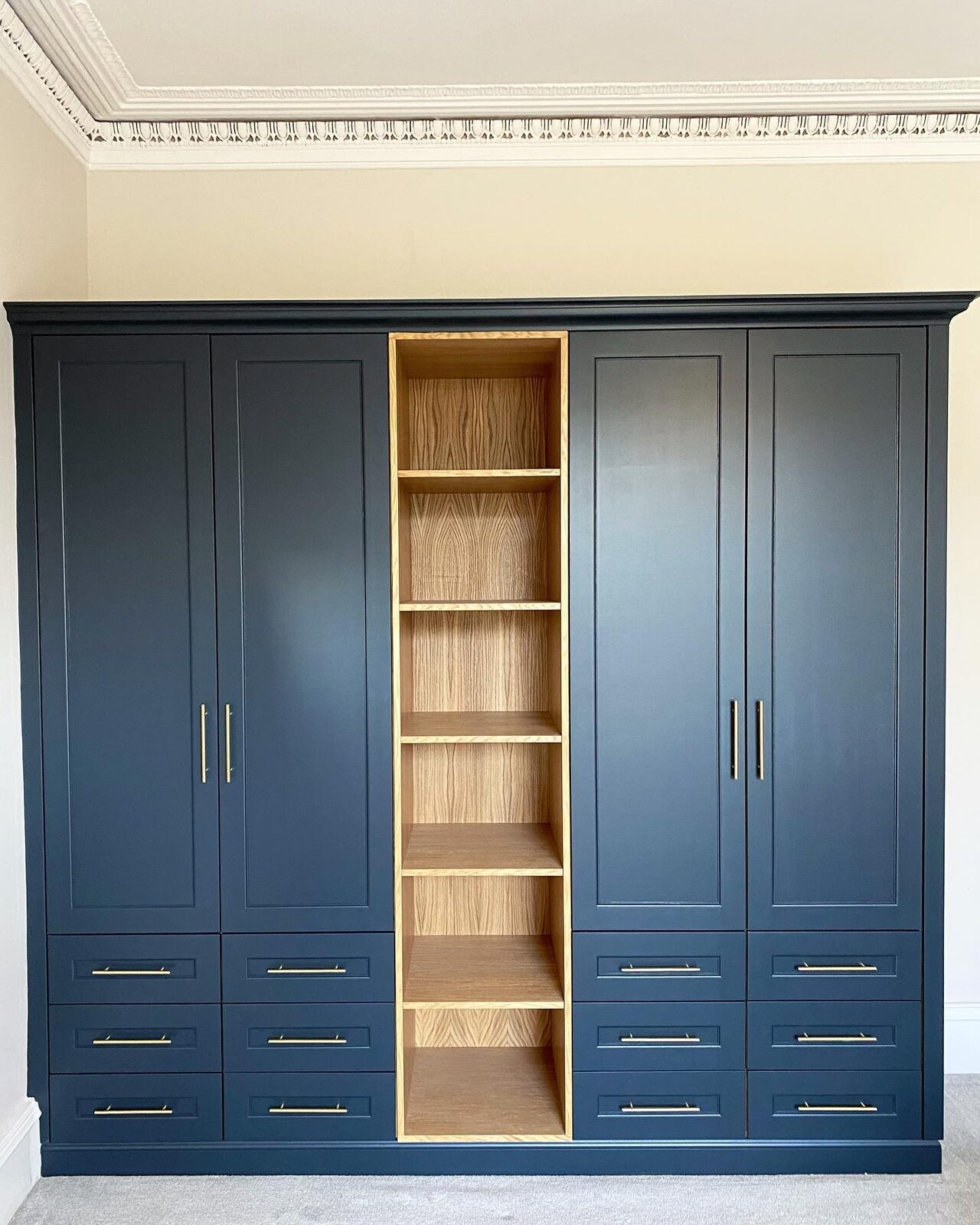 Navy blue fitted wardrobe with oak interior shelving