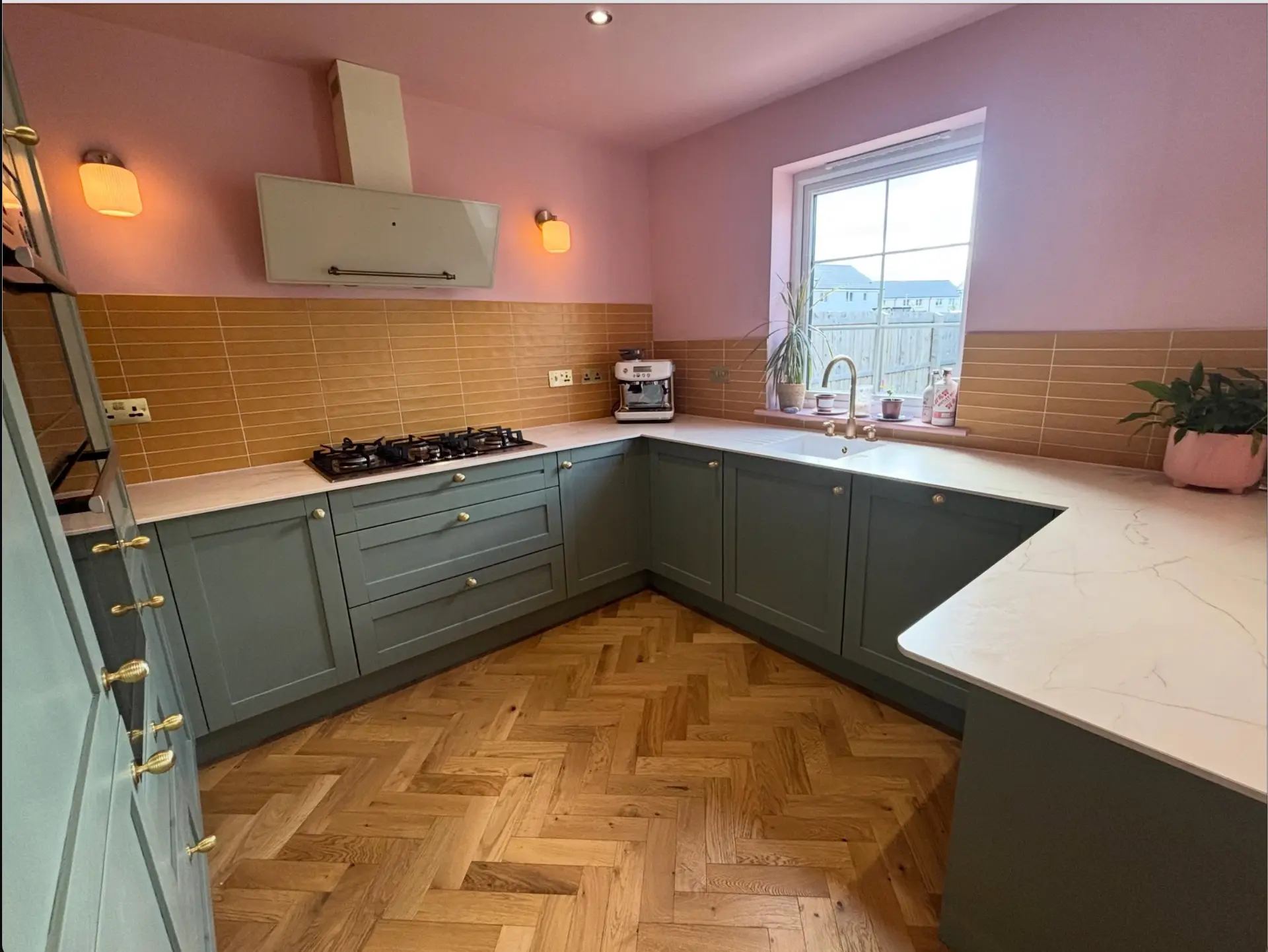 Sage green shaker kitchen with herringbone oak floor