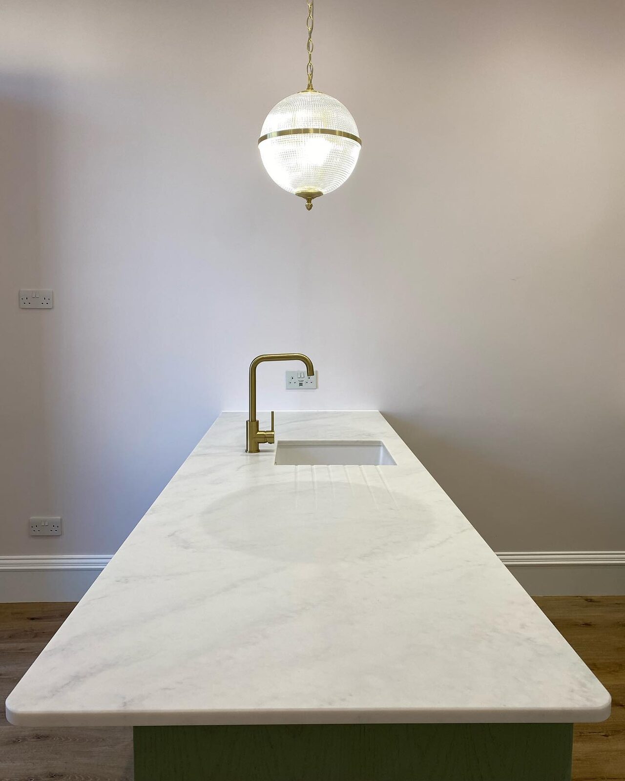 Kitchen island with marble worktop and brass tap